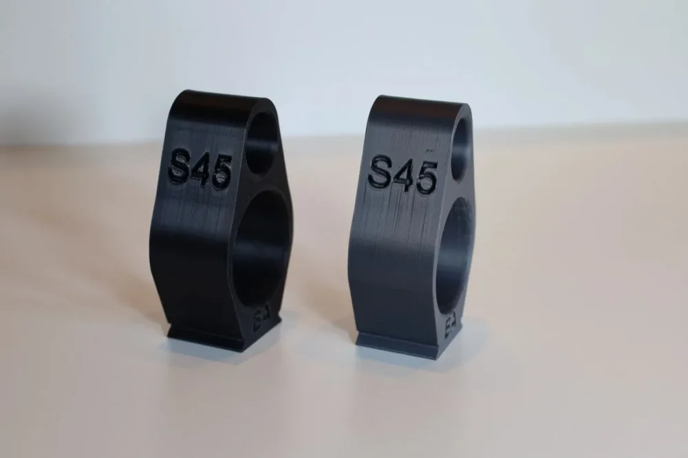Here's an alt tag for the image: Two S45 3D-printed parts.