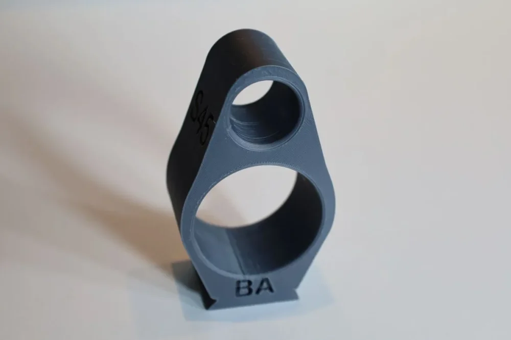 Gray 3D-printed double-ring firearm part.