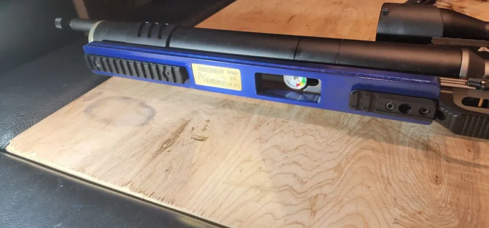 Here's an alt tag for the image: Blue air rifle with pressure gauge.