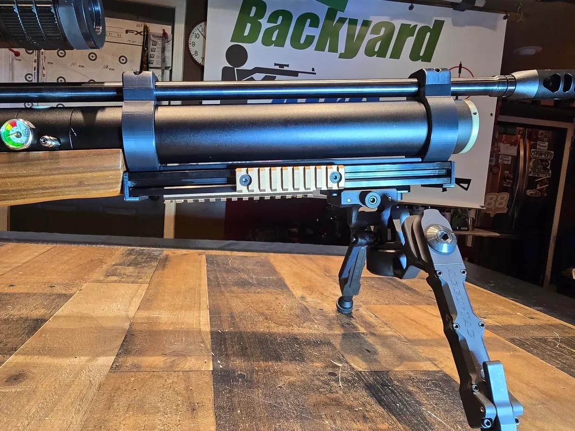 Air rifle with bipod on wooden table.