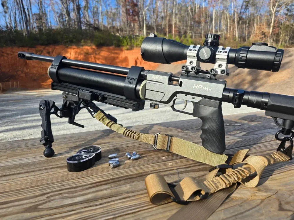 Airgun with scope and pellets on table.